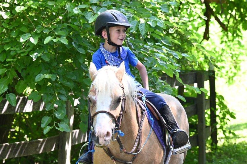 smiling child on pony at pony camp