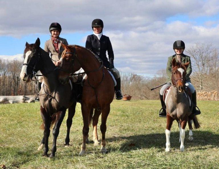 3 juniors in foxhunting attire, on horses